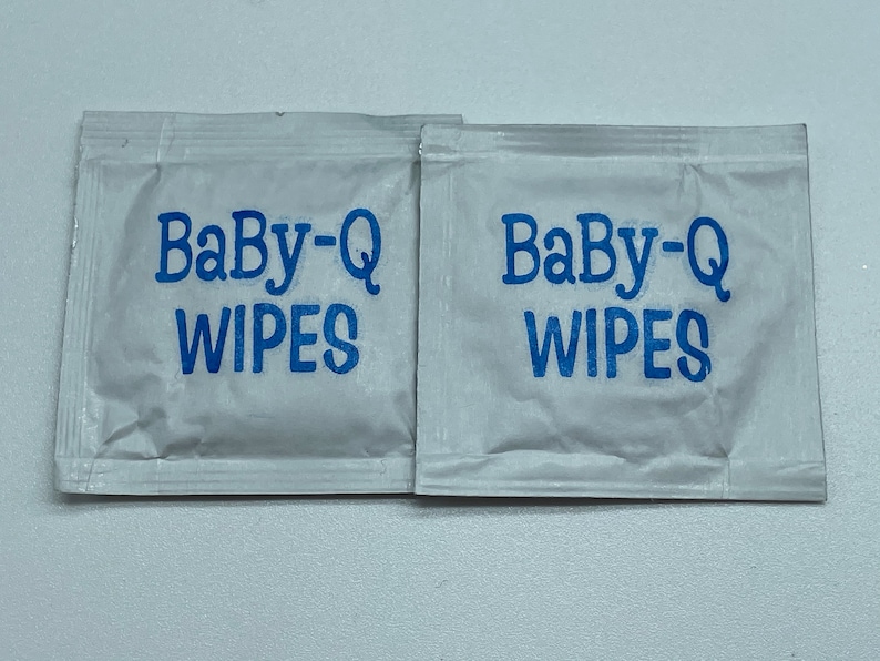 May include: Two individual packets of Baby-Q wipes, each with the brand name printed in blue on a white background.