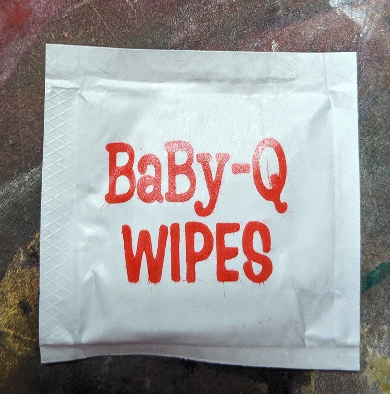 May include: A white package with red text that reads "Baby-Q Wipes".