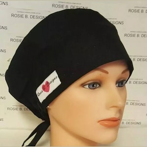 May include: Black scrub hat with a pink heart and the text "Rosie B. Designs" on a white label.
