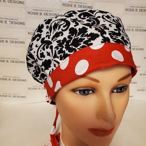 May include: A red and white polka dot surgical scrub hat with a black and white damask pattern. The hat has a red band with white polka dots and ties that are also red and white polka dots.