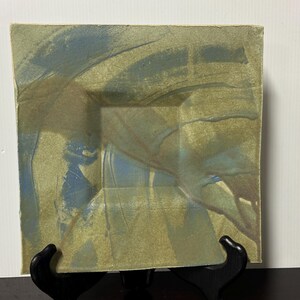 Può includere: Piatto quadrato in ceramica con una glassa verde e blu. La glassa ha un effetto marmorizzato con striature blu e verdi.