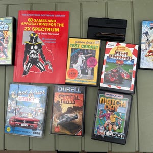 Può includere: Una collezione di software ZX Spectrum che include un libro rosso intitolato 60 Games and Applications for the ZX Spectrum, una cartuccia nera e sette custodie di giochi con titoli come Super Soccer, Test Cricket, Pole Position, Biggles, Out Run, Critical Mass e Match Day.