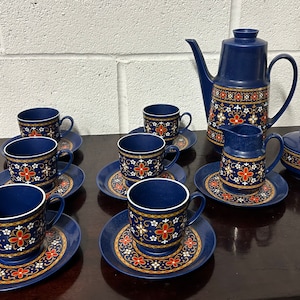 Puede incluir: Un juego de té azul y blanco con flores con tetera, jarra de crema, azucarero y seis tazas y platillos.