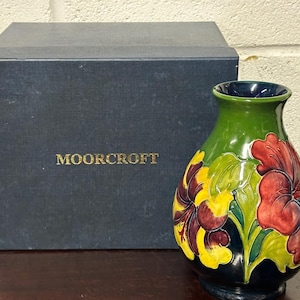 Moorcroft vas med korallrosa hibiskusmönster och grön bakgrund, signerad på basen med Moorcroft presentask