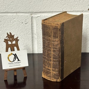 Peut inclure: Un livre relié vintage de couleur marron avec le titre "Galaxy Science" sur le dos. Le livre est posé sur une surface en bois brun foncé.