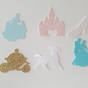 May include: A set of six Cinderella-themed paper cutouts. The cutouts are in various colors, including light blue, pink, white, and gold. The cutouts include Cinderella, Prince Charming, a glass slipper, a horse, a carriage, and a castle.