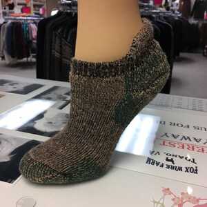 May include: Camouflage patterned ankle socks with a green and brown color scheme.
