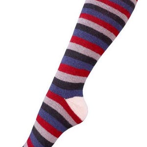 May include: Knee-high sock with horizontal stripes in red, gray, blue, and black. The toe and heel are light pink. The sock is angled diagonally from the bottom left to the top right.