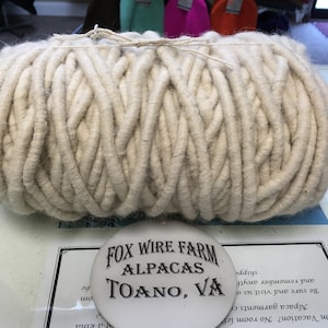 Könnte beinhalten: Eine große Rolle naturweißer Alpaka-Wolle, bereit zum Stricken oder Häkeln. Die Wolle wird von Fox Wire Farm Alpacas in Toano, VA hergestellt.
