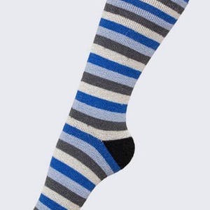 May include: A knee-high sock with horizontal stripes in shades of blue, gray, and white. The heel and toe are black. The sock is made of a soft, knitted material.
