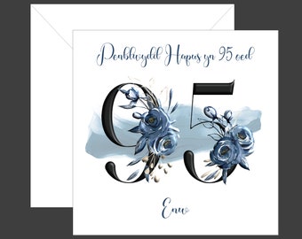 May include: A white card with blue watercolor accents and black floral embellishments. The number 95 is written in black with the text "Penblwydd Hapus yn 95 oed" and "Ewch" in black cursive.