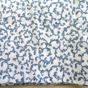 May include: White fabric with a blue floral pattern. The pattern is made up of small, delicate branches and leaves.