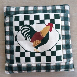 May include: Square green and white checkered pot holder with a rooster design. The center features a white oval with a colorful rooster illustration. The border is a green and white checkered pattern.