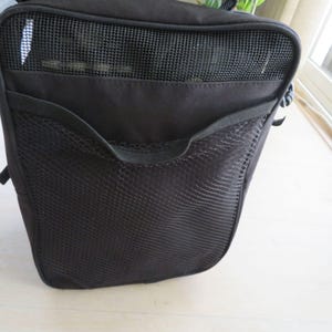 May include: Black bag with a mesh pocket and a mesh top. The bag has a rectangular shape and a small handle. The mesh pocket is on the front of the bag. The bag is made of a durable material.