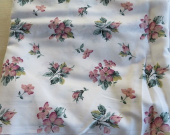 May include: White fabric with a repeating pattern of pink flowers and green leaves.