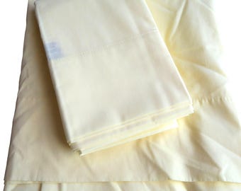 May include: A set of two yellow pillowcases. The pillowcases are made from a soft, smooth fabric and have a subtle sheen.