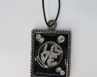 Collar con colgante de esmalte negro y diseño de "Amor" con diamantes de imitación en el cordón, estilo vintage de los años 90.