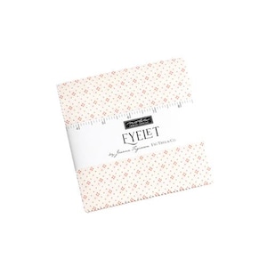 May include: A white fabric square with a small, repeating pattern of red dots. The fabric is labeled "Eyelet" by "Fig Tree & Co."