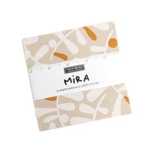 May include: A stack of fabric squares with a beige background and a repeating pattern of white and orange leaf-like shapes. The fabric is wrapped with a white band that reads "MIRA" and "by Brigitte Heitland for ZEN CHIC".