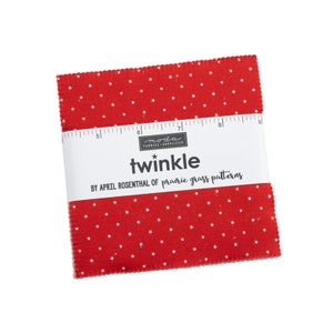 May include: A red fabric square with white stars printed on it. The fabric is labeled "twinkle* by April Rosenthal of prairie grass patterns".