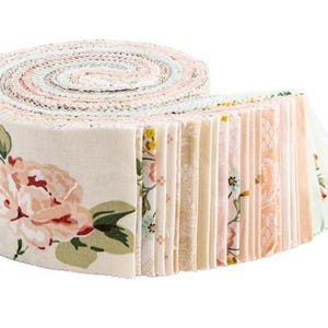 May include: Rolled fabric strips in a floral print, featuring a cream background with pink and green floral designs. The roll is partially unraveled, revealing a stack of coordinating fabric strips in various pastel colors.