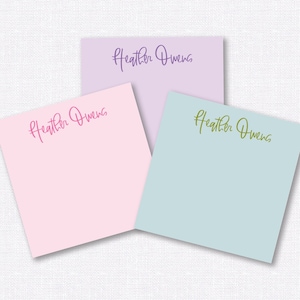 May include: Three personalized sticky note pads with the name "Heather Owens" written in different colors on each pad. The pads are pink, light blue, and lavender.
