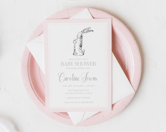 May include: A pink and white baby shower invitation with a black and white illustration of a rabbit. The invitation reads "Please join us for a Baby Shower honoring mother-to-be Caroline Jones, May 6th, 12:00 PM - 4:00 PM, 5555 Long John Cove, Mountain Brook, AL 35223, Registered at Babylist, RSVP to Koryn at 555-555-5555."