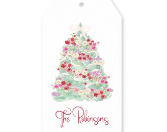 May include: A white gift tag featuring a watercolor Christmas tree design. The tree is adorned with red, pink, and white flowers, with a light green base and a cream-colored bow at the top. The text "The Robinsons" is written in red script.