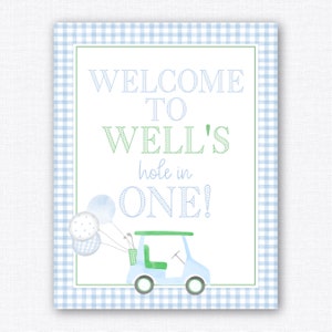 May include: A blue and green welcome sign with a golf cart and balloons. The sign says "Welcome to Well's Hole in One!"