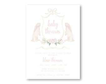 May include: A pink and white baby shower invitation with a crest featuring two white bunnies and pink flowers. The text reads "baby thomas" and "blair thomas".