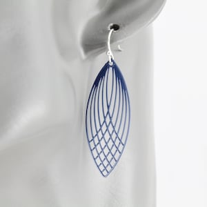 May include: A pair of blue geometric dangle earrings with a silver hook. The earrings are made of thin metal wires that are woven together to create a delicate and intricate design.