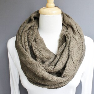 May include: A brown cable knit infinity scarf. The scarf is made of a soft, warm material and is perfect for keeping you warm in the winter.