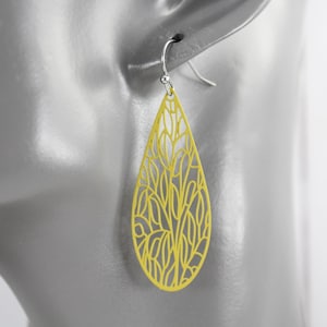 May include: A bright yellow teardrop-shaped earring featuring an intricate, openwork filigree pattern of organic, leaf-like lines. The earring hangs from a simple silver-toned metal hook, creating a delicate and lightweight appearance.