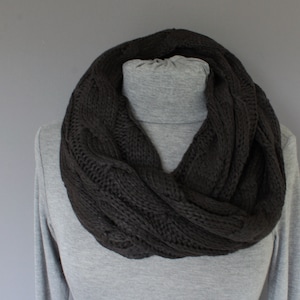 May include: A dark brown cable knit infinity scarf. The scarf is made of a soft, cozy material and is perfect for keeping warm in the winter.