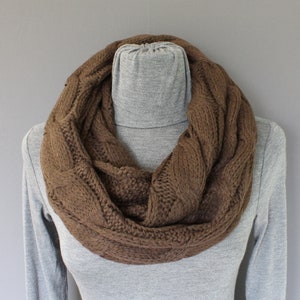 May include: A brown cable knit infinity scarf. The scarf is made of a soft, warm material and is perfect for keeping you cozy in the cold weather.