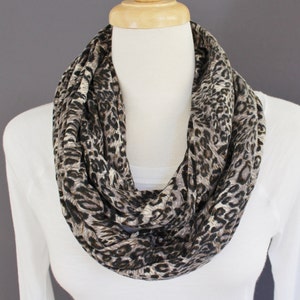 May include: A brown and beige infinity scarf with a leopard print pattern.