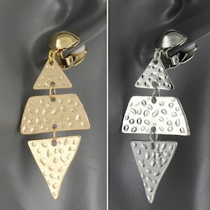 May include: A pair of dangle earrings with a textured, geometric design. The earrings are available in gold and silver.