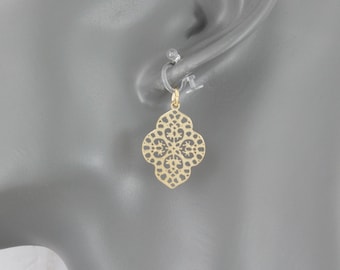 Könnte beinhalten: Goldene filigranartige Ohrhänger mit einem zarten, filigranen Design. Die Ohrringe sind an einem Mannequin-Ohr zu sehen.