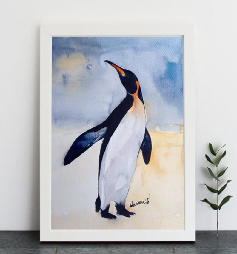 Puede incluir: Pintura acuarela de un ping&uuml;ino de pie sobre un fondo blanco con un cielo azul claro en el fondo. El ping&uuml;ino est&aacute; mirando hacia la derecha y tiene un cuerpo blanco y negro con un pico amarillo y marcas naranjas alrededor de los ojos.