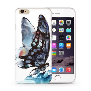 May include: A white iPhone case with a watercolor painting of a blue butterfly with black wings. The butterfly is in flight and has a rainbow-colored gradient on its wings.