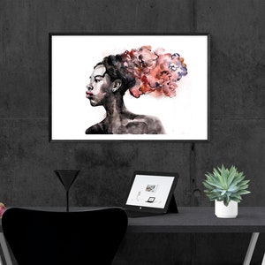 May include: A black and white watercolor painting of a person with a red and pink floral design in their hair. The painting is framed and hanging on a gray wall.
