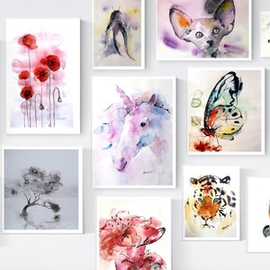 Puede incluir: Una pared de galer&iacute;a con pinturas de acuarela que presentan una variedad de temas, incluyendo flores, animales y dise&ntilde;os abstractos. Las pinturas est&aacute;n enmarcadas en blanco y dispuestas en una cuadr&iacute;cula.