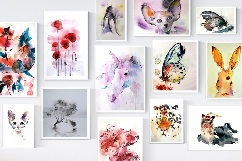 Puede incluir: Una pared de galer&iacute;a con pinturas de acuarela que presentan una variedad de temas, incluyendo flores, animales y dise&ntilde;os abstractos. Las pinturas est&aacute;n enmarcadas en blanco y dispuestas en una cuadr&iacute;cula.