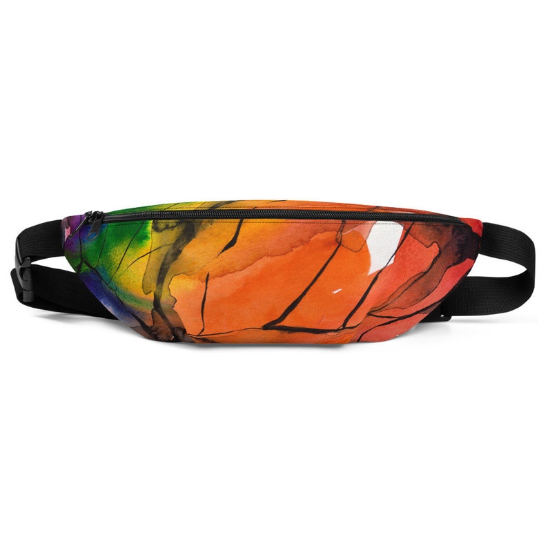 May include: A black fanny pack with a zipper closure. The fanny pack is decorated with a colourful abstract watercolour design featuring shades of orange, yellow, green, and blue.