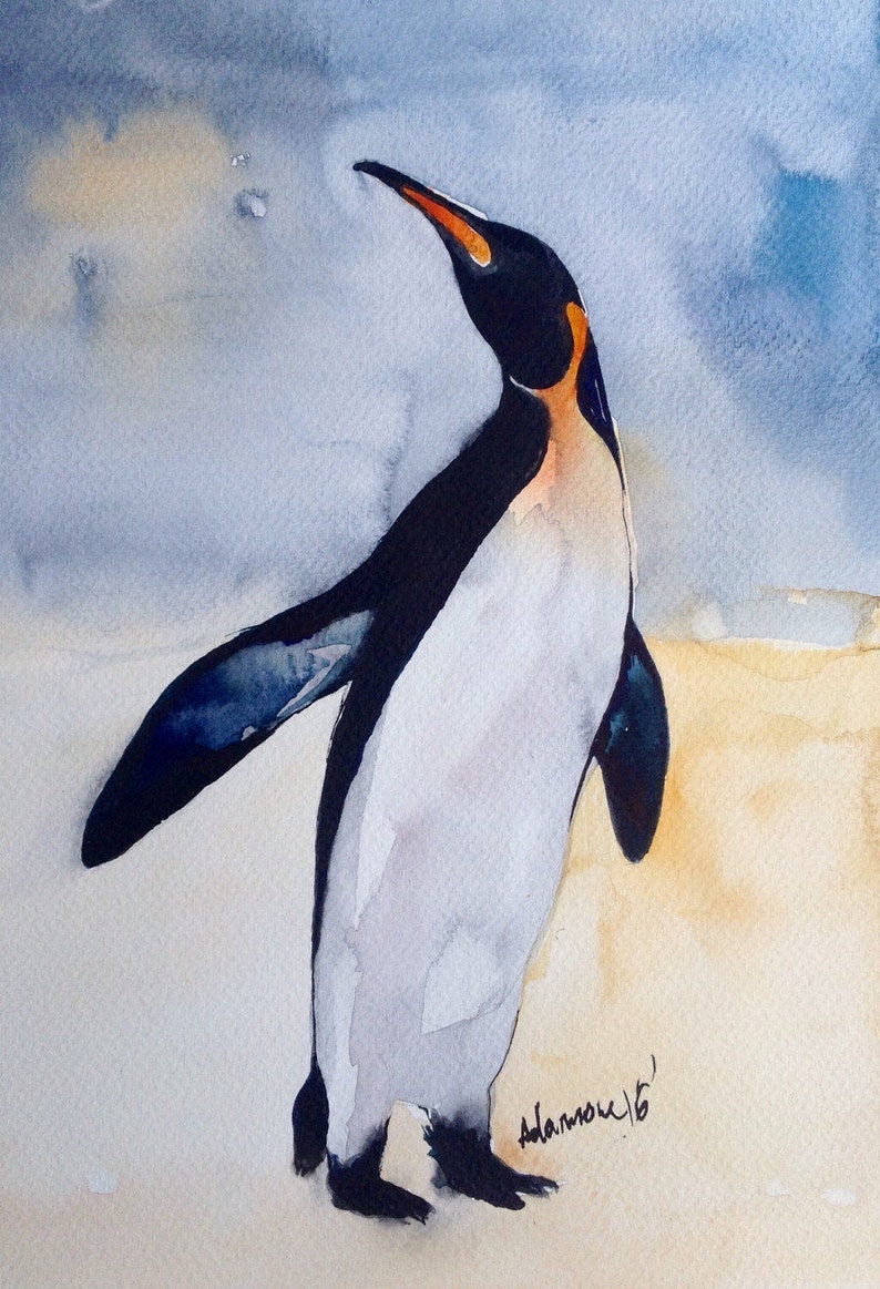 Puede incluir: Pintura acuarela de un ping&uuml;ino rey de pie en una playa de arena con un cielo azul de fondo. El ping&uuml;ino est&aacute; mirando hacia la derecha y hacia arriba. La firma del artista est&aacute; en la esquina inferior derecha.