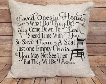 May include: A beige throw pillow with black text that reads "Loved Ones in Heaven What Do They Do? They Come Down To Earth To Spend Time With You. So Save Them A Seat Just One Empty Chair. You May Not See Them But They Will Be There."