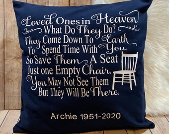 May include: A navy blue throw pillow with white text that reads "Loved Ones in Heaven What Do They Do? They Come Down To Earth To Spend Time With You. So Save Them A Seat Just One Empty Chair. You May Not See Them But They Will Be There."  The pillow also has a white silhouette of a chair and the text "Archie 1951-2020".