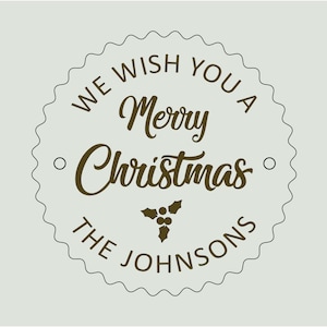 May include: A brown and white circular Christmas greeting with the text "We wish you a Merry Christmas" and "The Johnsons" in a decorative font.