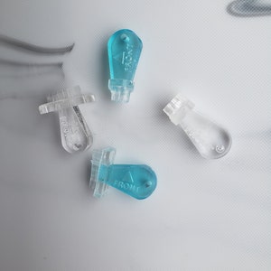 May include: Four plastic key-shaped objects with the word "FRONT" printed on them. Three are clear and one is light blue.