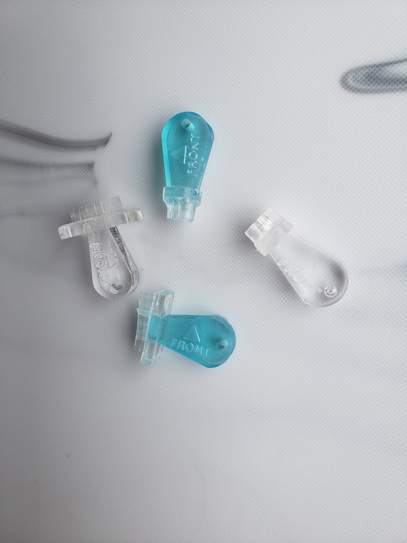 May include: Four plastic key-shaped objects with the word "FRONT" printed on them. Three are clear and one is light blue.